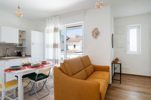 a kitchen and a living room with a table and a couch at Eleven House by BarbarHouse in Bari