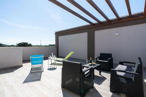 a patio with chairs and tables on a roof at Eleven House by BarbarHouse in Bari