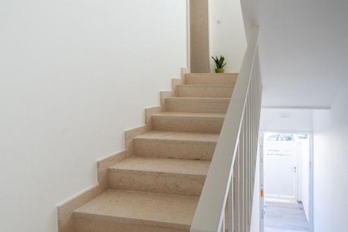 a staircase in a home with white walls and white stairs at Eleven House by BarbarHouse in Bari