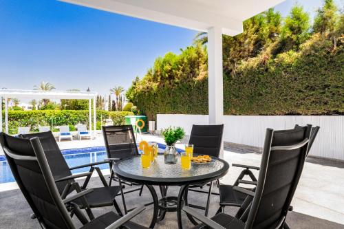 a patio with a table and chairs next to a pool at Villa Zina by Ezoria Villas in Meneou