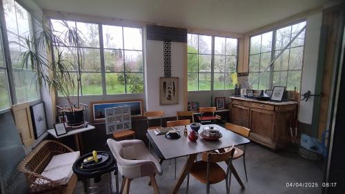 une pièce avec une table, des chaises et des fenêtres dans l'établissement LE Garden, à Albi