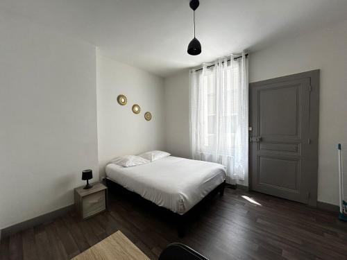 une chambre blanche avec un lit et une fenêtre dans l'établissement Le Hoche&Chill, proche de la Gare, à Limoges