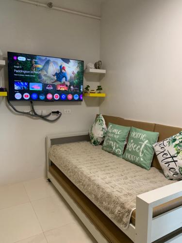 a living room with a couch and a flat screen tv at Modern Condo, Sea View, Fast Wifi, Cafe, Panglao in Dauis