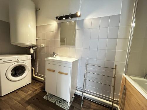une salle de bain avec une machine à laver et un lave-linge dans l'établissement Le Hoche&Chill, proche de la Gare, à Limoges