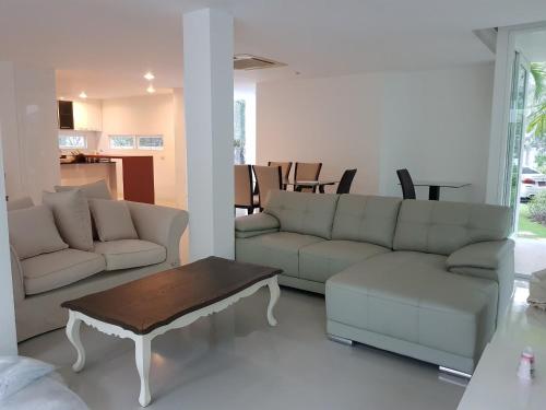 a living room with a couch and a coffee table at LELAWADEE Villa Cha -Am 