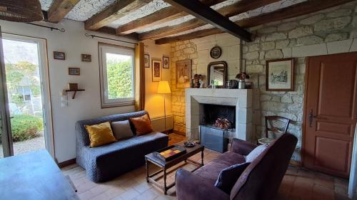 un salon avec un canapé et une cheminée dans l'établissement Le refuge des anges, à Beaumont-en-Véron