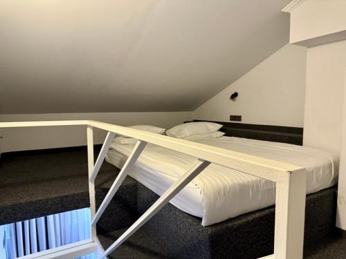 a bedroom with a bunk bed with white sheets at Deribas Hotel in Odesa