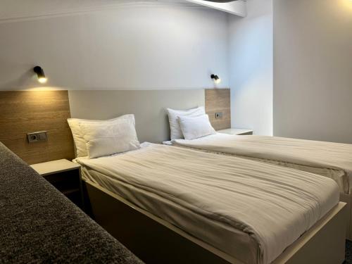 two beds in a small room with white walls at Deribas Hotel in Odesa