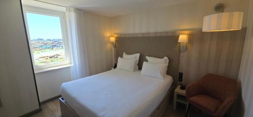 Ένα ή περισσότερα κρεβάτια σε δωμάτιο στο Logis Hôtel Saint Guirec Et De La Plage