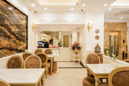 um restaurante com mesas e cadeiras e uma cozinha em Delina Castle Coffee & Hotel em Hanói