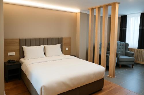 a bedroom with a bed and a blue chair at ERSA Hotel in Tuzla