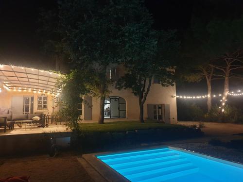 une piscine devant une maison la nuit dans l'établissement Bastide Contemporaine Gardoise, à Saint-Laurent-des-Arbres