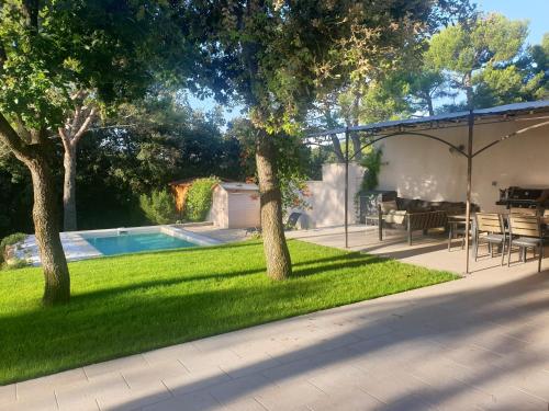 une arrière-cour avec une piscine et deux arbres dans l'établissement Bastide Contemporaine Gardoise, à Saint-Laurent-des-Arbres