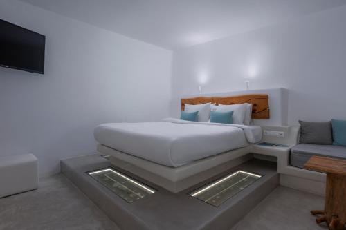 a bedroom with a bed and a couch at Flaskos Luxury Suites in Agios Stefanos