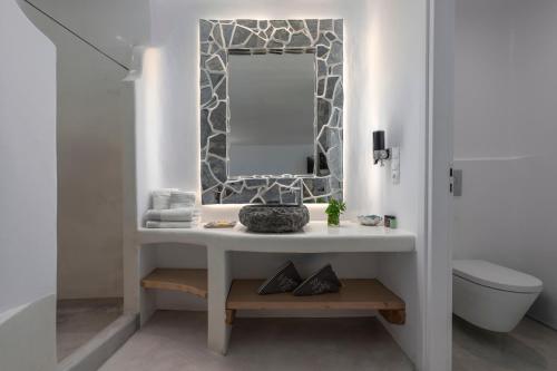 a bathroom with a sink and a mirror at Flaskos Luxury Suites in Agios Stefanos
