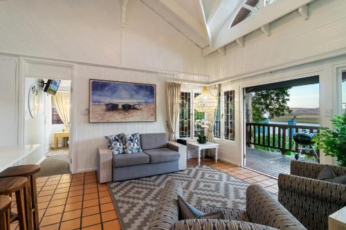 a living room with a couch and a table at Knysna River Club Getaways - Luxury waterfront chalets in Knysna