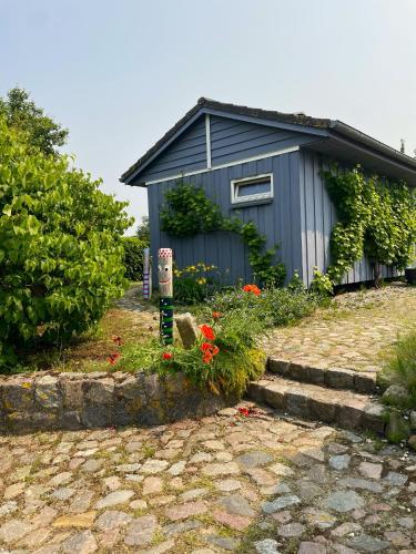 a blue house with some flowers in front of it at Vogelhaus Gobbin in Lancken-Granitz