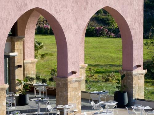 an outdoor patio with two arches with tables and chairs at Boutique 5 Hotel & Spa - Adults Only in Kiotari
