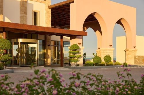 a building with arches and flowers in the foreground at Boutique 5 Hotel & Spa - Adults Only in Kiotari