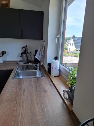 a kitchen with a sink and a large window at Servus & Moin - Bei uns Daheim! in Meißendorf