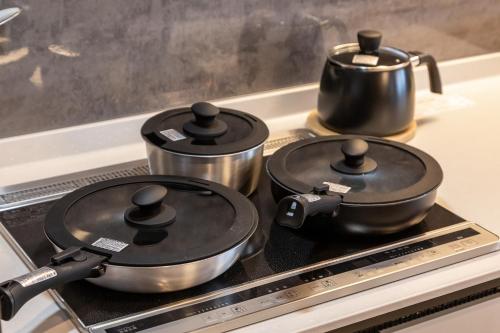 a stove top with two pots and a tea kettle at The SKY in Sapporo