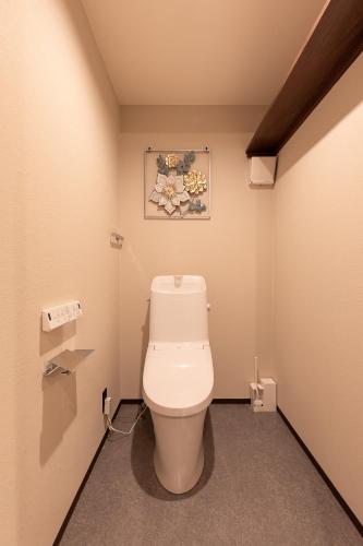 a bathroom with a toilet with a picture on the wall at The SKY in Sapporo