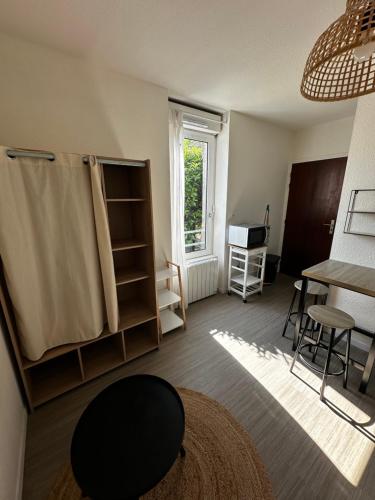 un salon avec une table et une fenêtre dans l'établissement Studio paisible, à Vannes