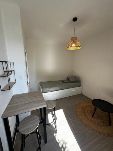 une petite pièce avec un lit, une table et des chaises dans l'établissement Studio paisible, à Vannes