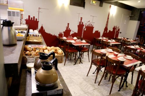 a restaurant with tables and chairs in a room at Hotel Paris Villette in Paris
