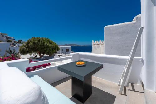 a table on a balcony with a view of the ocean at Flaskos Luxury Suites in Agios Stefanos
