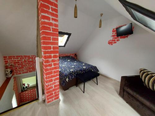 a attic room with a bed and a mirror at Przylesie Dom Turystyczny in Ostróda