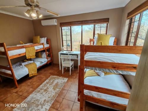 een kamer met 3 stapelbedden en een bureau bij Lion's Pride - Marloth Park in Marloth Park