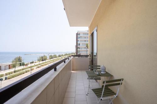 a balcony with chairs and a table and a view of the ocean at Dimora Waterfront in Bari