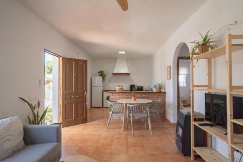 a kitchen and living room with a table and chairs at Los jardines de Zahora C02 in Cádiz