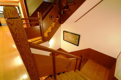 a wooden staircase in a house with a picture on the wall at 高野山 宿坊 総持院 -Koyasan Shukubo Sojiin- in Koyasan