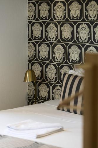 a bed in a room with a wall with a pattern at Villa Ikaros in Agia Triada