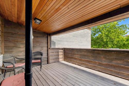 a wooden porch with two chairs and a window at The Loft in Whitefish