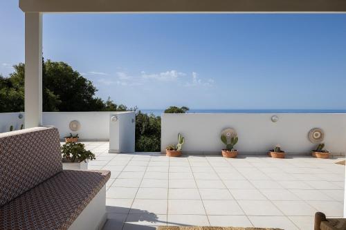 a patio with potted plants and a bench at Villa Ikaros in Agia Triada