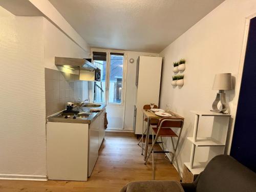 une petite cuisine avec un évier et une table dans l'établissement Bleu Nuit à Rouen - 390, à Rouen