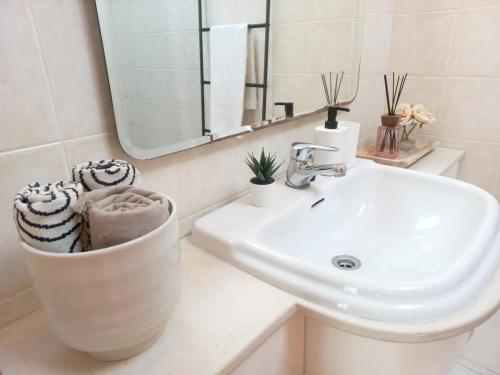 a white bathroom with a sink and a mirror at Pena's Family Beach House in Arcozelo