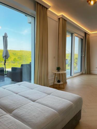 a bedroom with a large bed and a large window at Emerald Home in Suceava