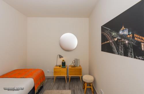 a room with a bed, a desk and a lamp at Passos Manuel by Innapartments in Porto