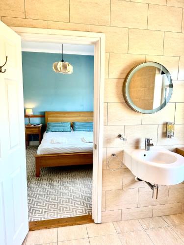 a bathroom with a bed and a sink and a mirror at St George's Hotel in Perranporth