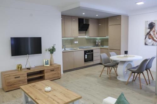 a kitchen with a table and a tv in a room at Apartmani Lepojevic in Prokuplje
