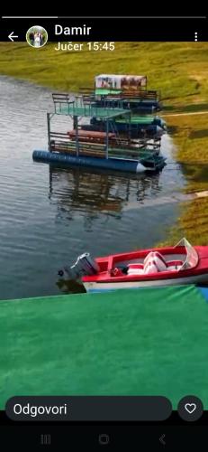 a red boat on the water next to a dock at Auto Camping Grubeša in Dronjići