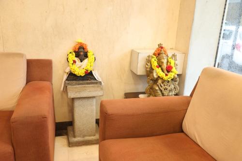 a room with two chairs and a table with flowers at NewGoldenResidency in Bengaluru