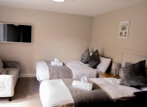 a hotel room with three beds and a couch at Fresh & Modern Studio Sleeps 3 in Thornton Heath