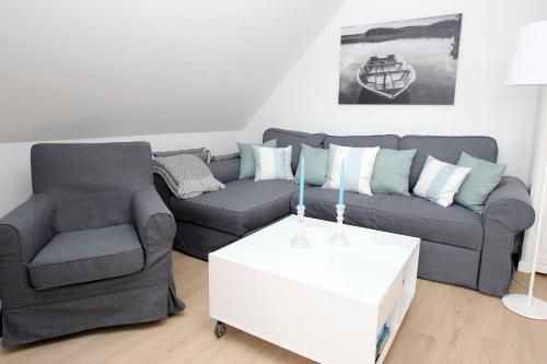 una sala de estar con un sofá y una silla en Vorderreihe, Fewo 157, en Travemünde