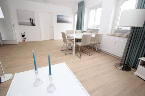 Un comedor con una mesa con dos velas encima. en Vorderreihe, Fewo 157, en Travemünde