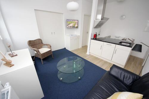 Una sala de estar con un sofá y una mesa de cristal. en Vorderreihe, Fewo 108, en Travemünde